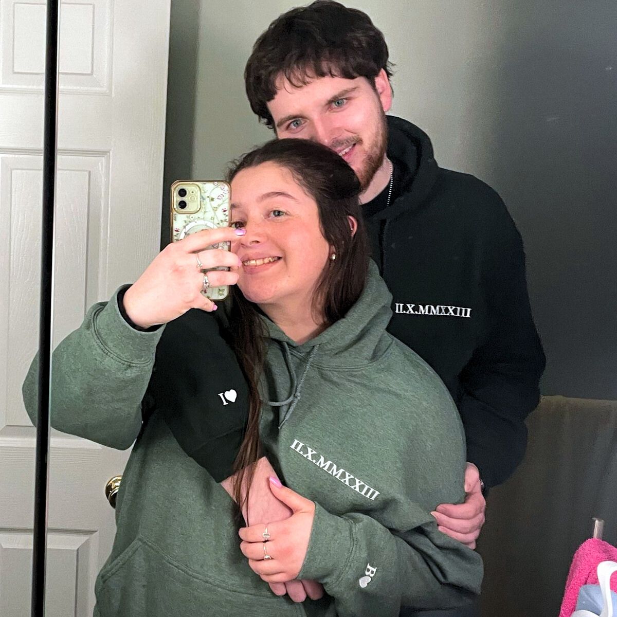 Happy couple wearing roman sweatshirt with initials on sleeve