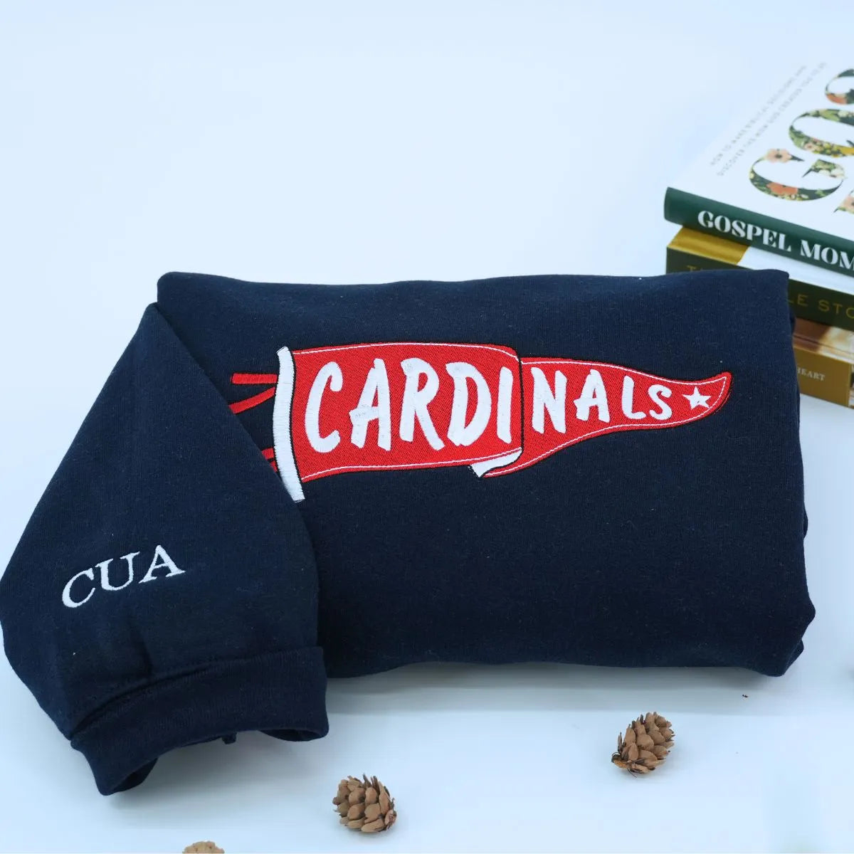 Custom embroidered black pennant sweatshirt folded on table – personalized team name sweatshirt for school spirit, game day, and sports fans