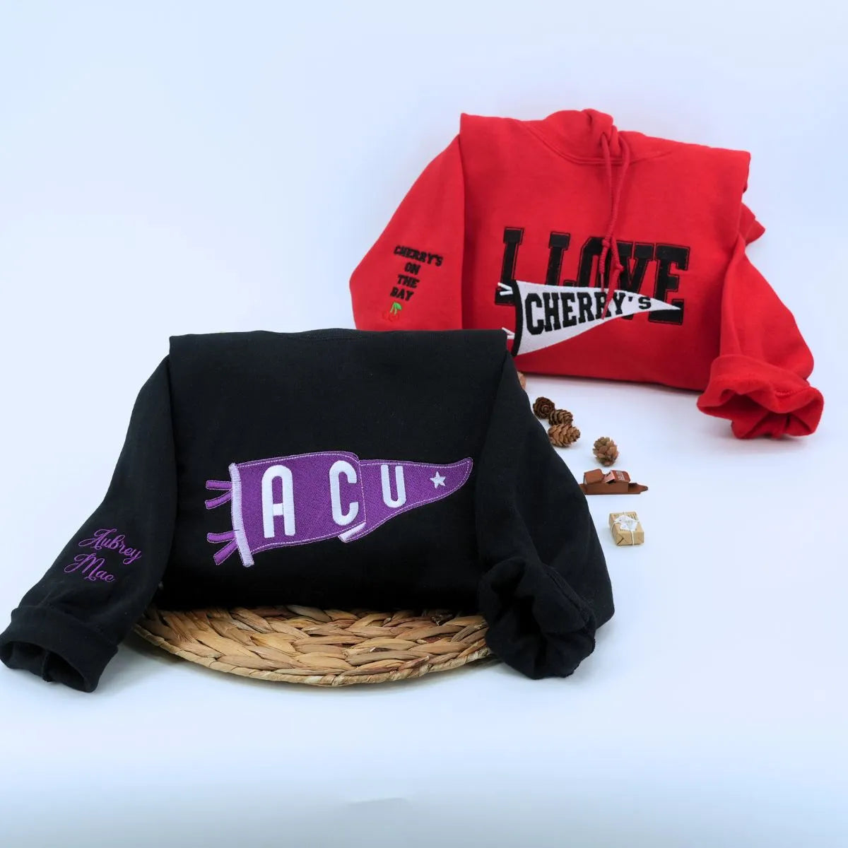 Custom embroidered red and black pennant hoodies  folded on table – personalized team name hoodies for school spirit, game day, and sports fans