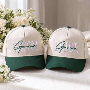 Custom embroidered Bride and Groom baseball caps in cream and forest green with personalized last name