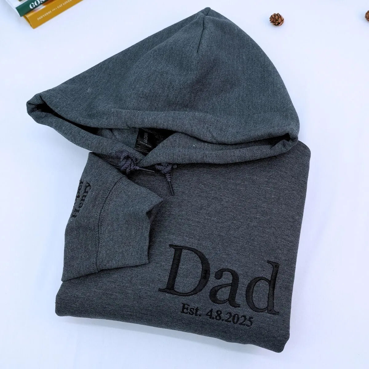 Dark Heather Dad Hoodie with EST. 2025 embroidery on chest and kids names on sleeve, a meaningful and cozy gift for new dad