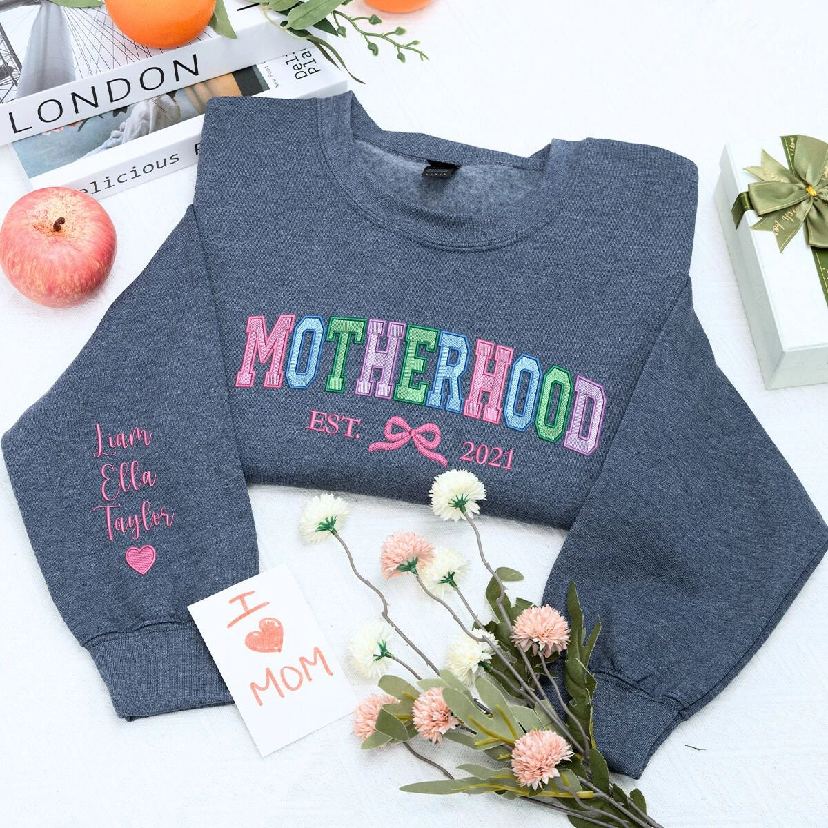 Motherhood dark heather sweatshier with 'Est. 2021' and coquette bow with kids names on sleeve, a meaningful and cozy gift for mama