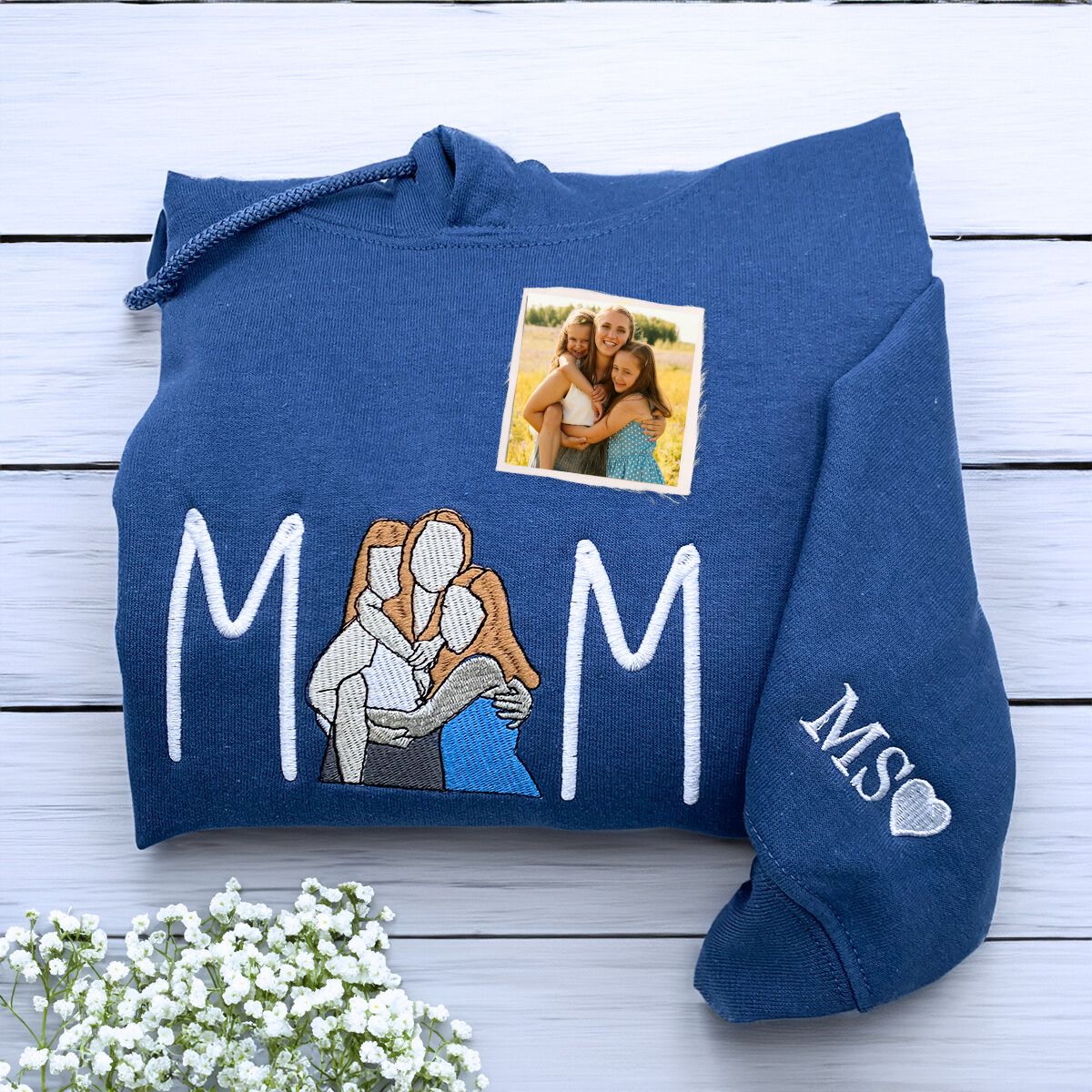 Folded Indigo Blue Mama Hoodie with Mom and Daughters Portrait Embroidery, a meaningful and cozy gift for Mother's day