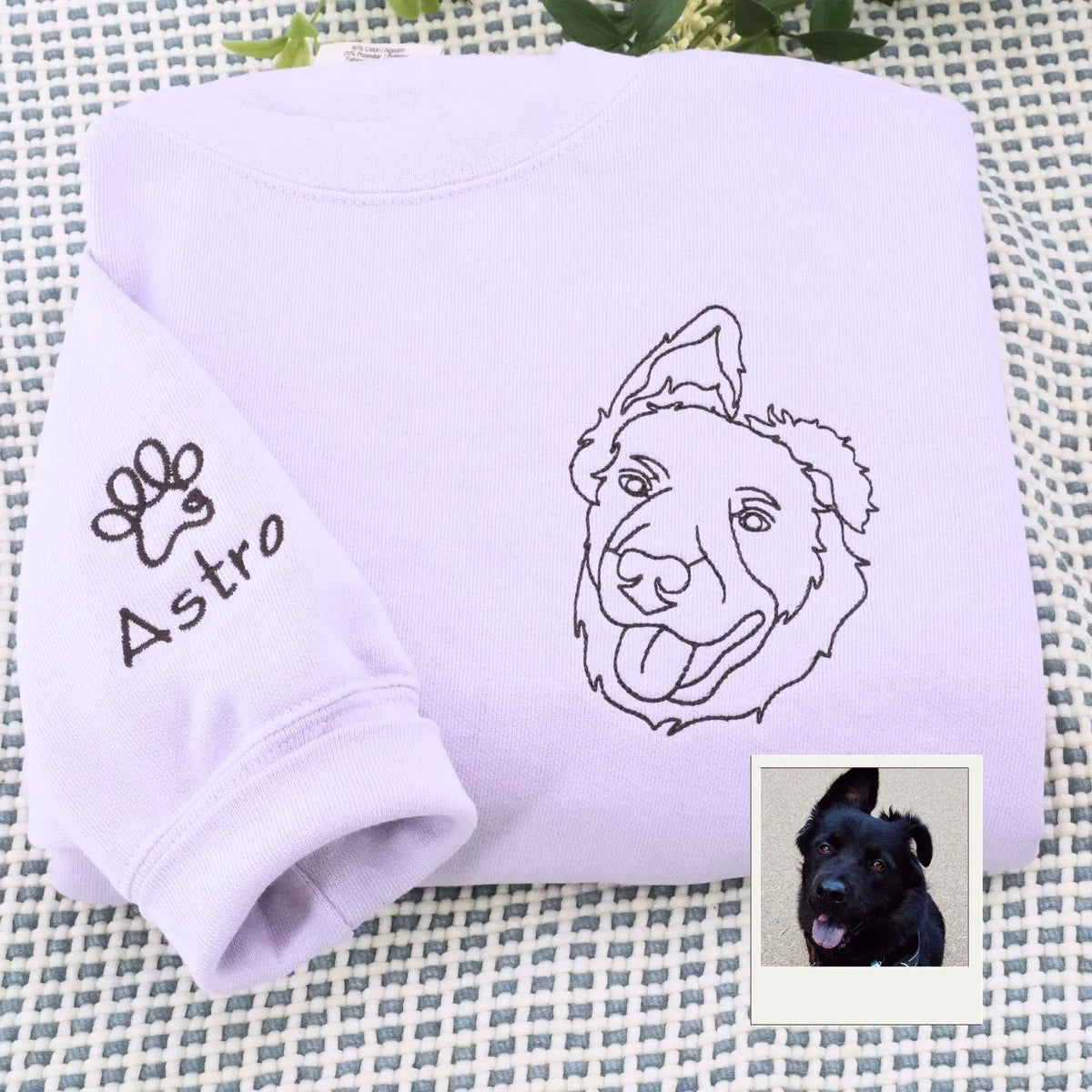 Close-up of personalized embroidery featuring a dog's face and name on a high-quality sweatshirt.