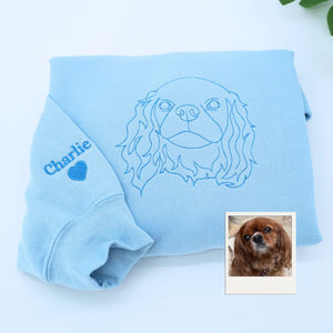 Close-up of personalized embroidery featuring a dog's face and name on a high-quality sweatshirt.