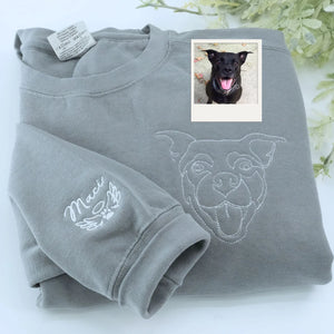 Close-up of personalized embroidery featuring a dog's face and name on a high-quality sweatshirt.