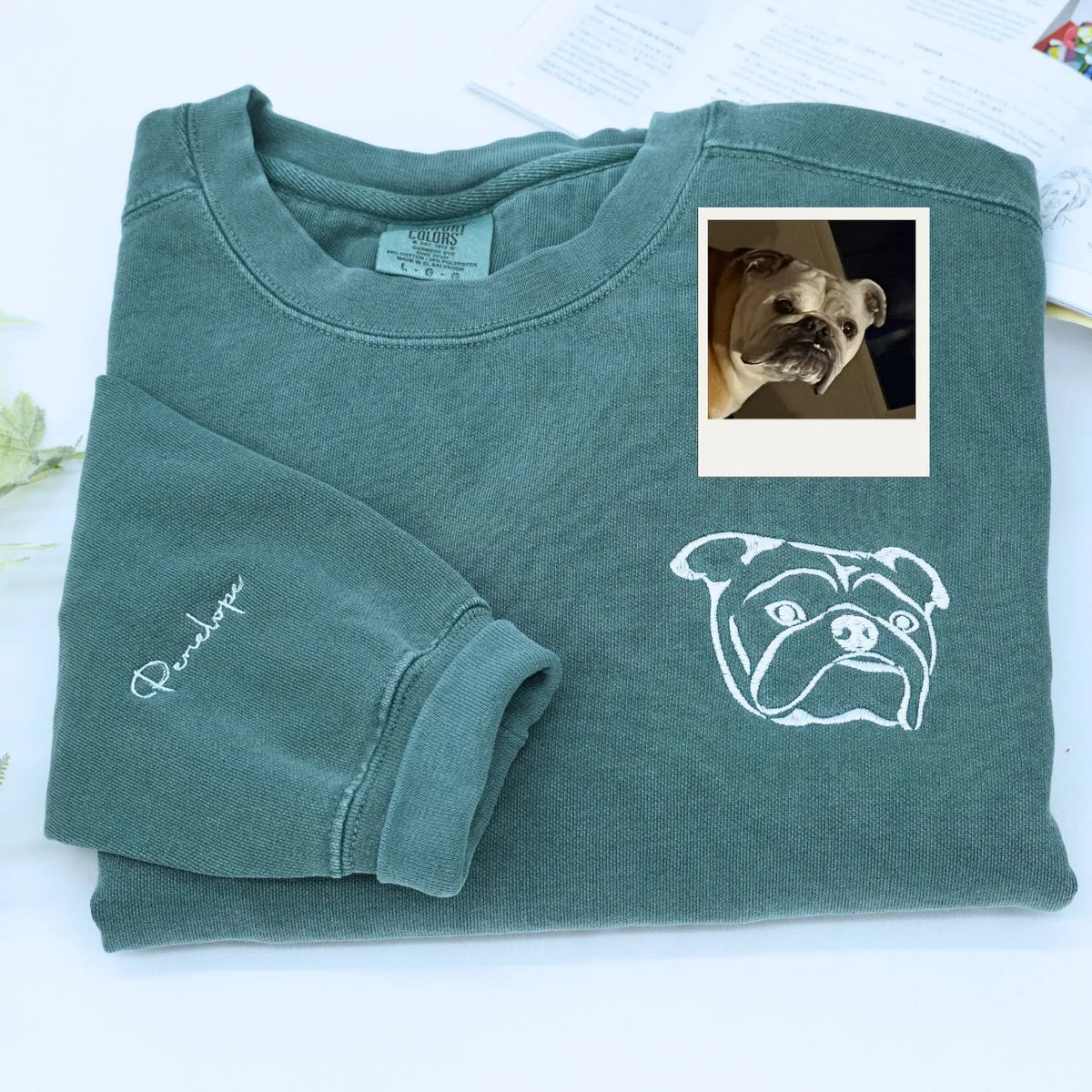 Close-up of personalized embroidery featuring a dog's face and name on a high-quality sweatshirt.