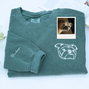Close-up of personalized embroidery featuring a dog's face and name on a high-quality sweatshirt.