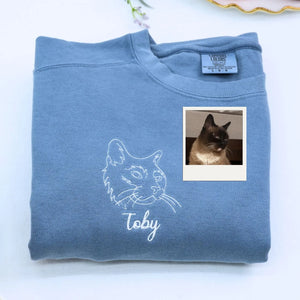 Close-up of personalized embroidery featuring a cat's face and name on a high-quality sweatshirt.