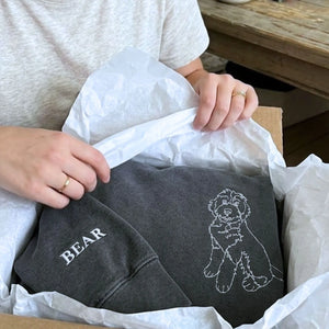 Close-up of personalized embroidery featuring a dog's face and name on a high-quality sweatshirt.