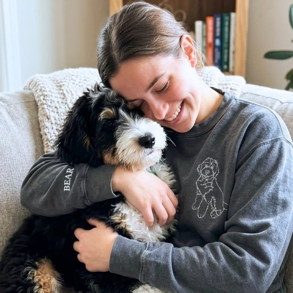 Close-up of personalized embroidery featuring a dog's face and name on a high-quality sweatshirt.
