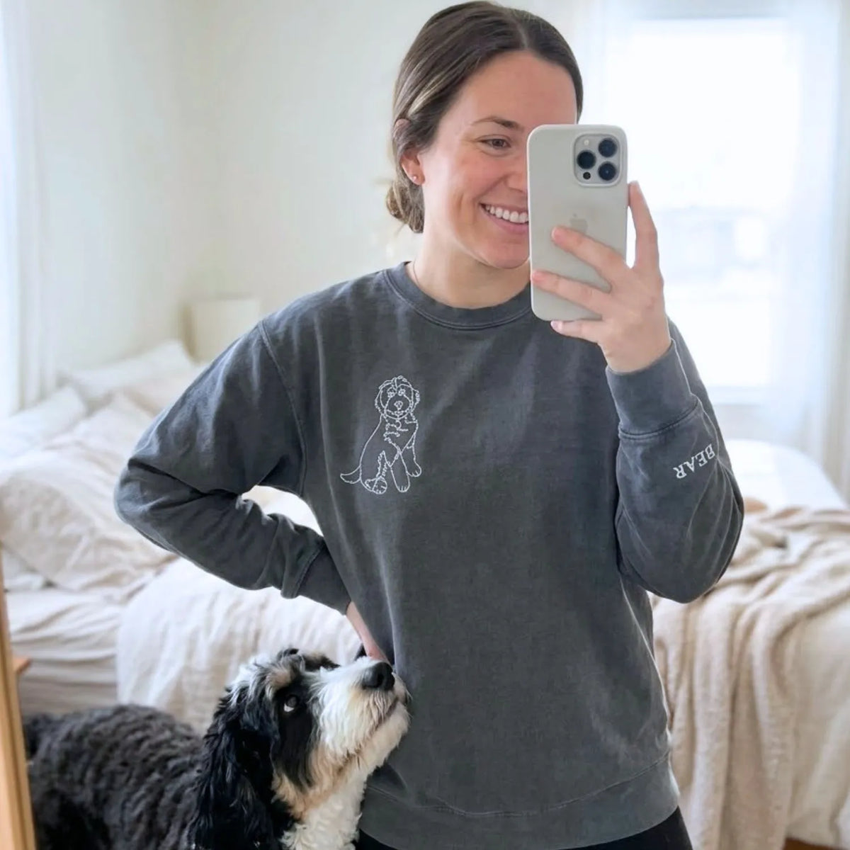 Close-up of personalized embroidery featuring a dog's face and name on a high-quality sweatshirt.