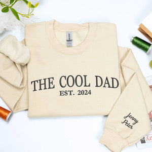 Sand The Cool Dad Sweatshirt with EST. 2024 embroidery and kid name on sleeve, a meaningful and cozy gift for dad