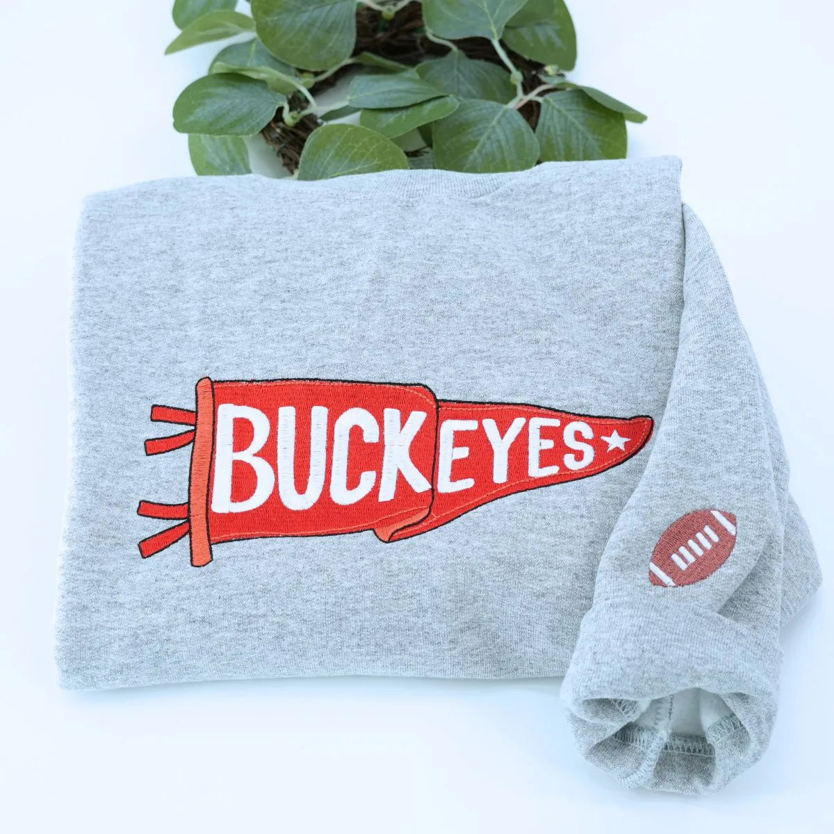 Custom embroidered sport gray pennant sweatshirt folded on table – personalized team name sweatshirt for school spirit, game day, and sports fans