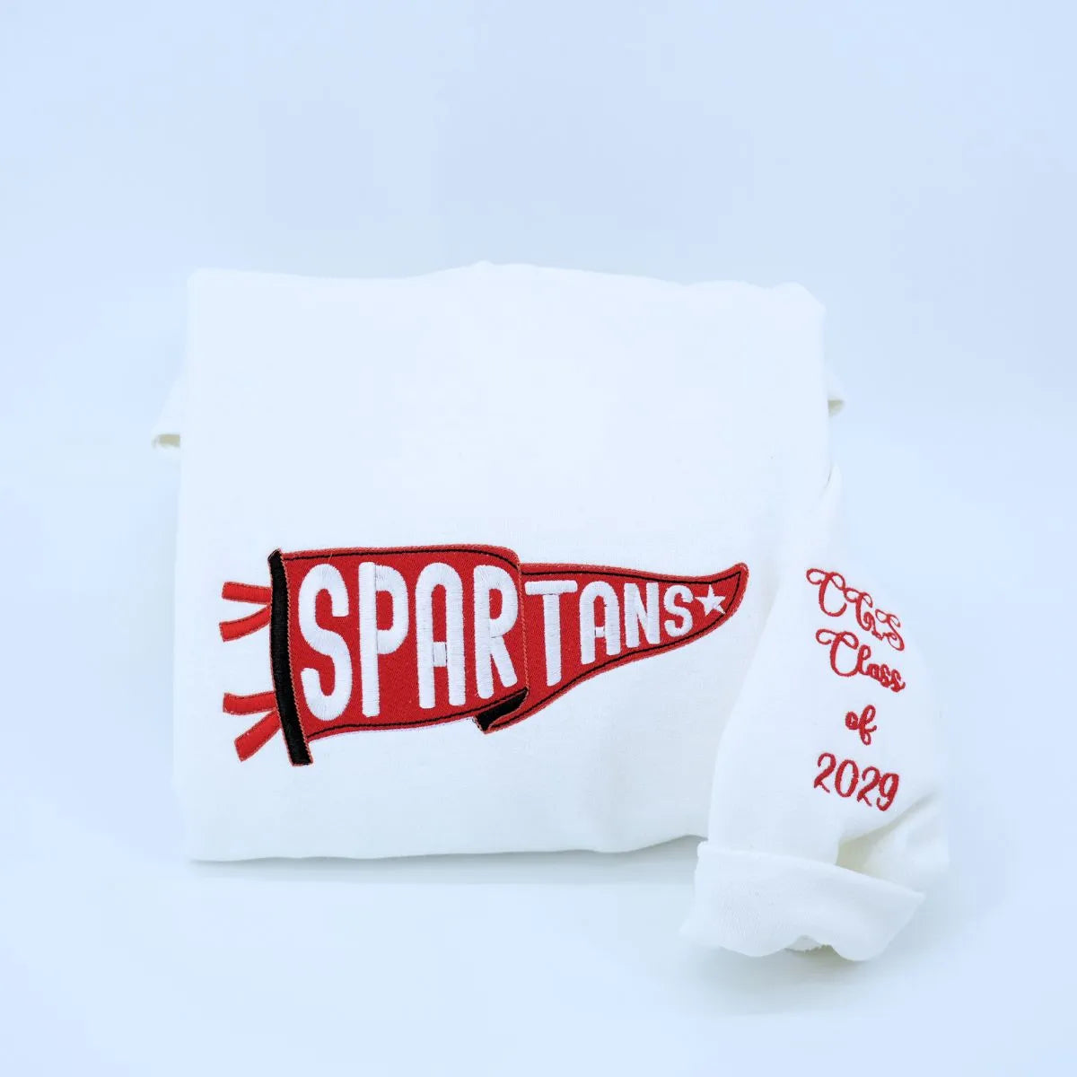 Custom embroidered white  pennant sweatshirt folded on table – personalized team name sweatshirt for school spirit, game day, and sports fans