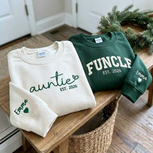 Folded sand Auntie and forest green Funcle embroidered sweatshirts with personalized sleeve names and hearts, a Christmas gift for an aunt and uncle.