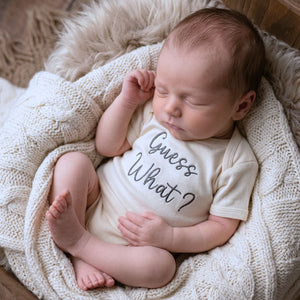 Embroidered “Guess What” baby onesie for pregnancy announcement, soft and cozy newborn bodysuit