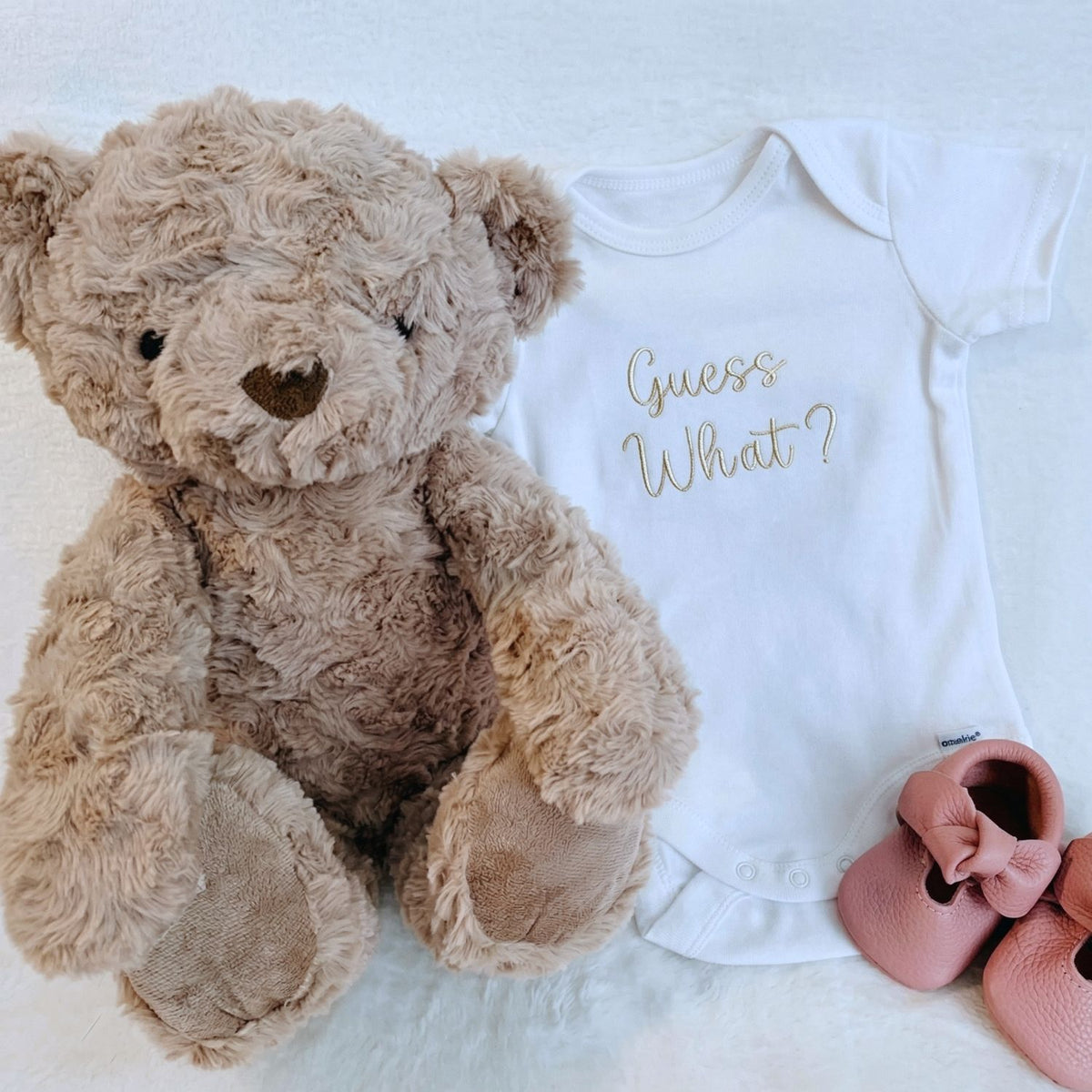 Embroidered “Guess What” baby onesie for pregnancy announcement, soft and cozy newborn bodysuit