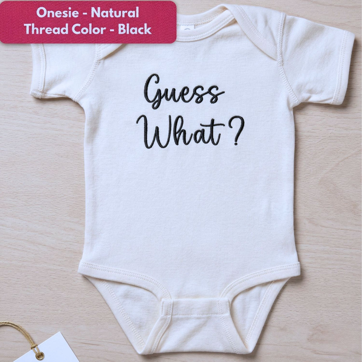 Embroidered “Guess What” baby onesie for pregnancy announcement, soft and cozy newborn bodysuit