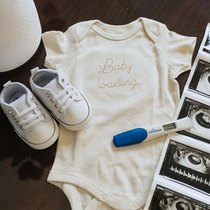 Embroidered baby announcement onesie with “Baby Loading” text for pregnancy reveal