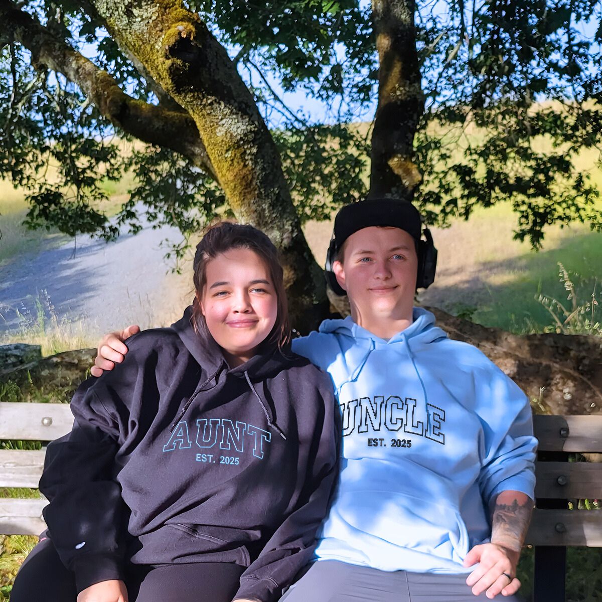 Matching embroidered 'Aunt' and 'Uncle' hoodies in black and blue, a cozy and meaningful gift for siblings.