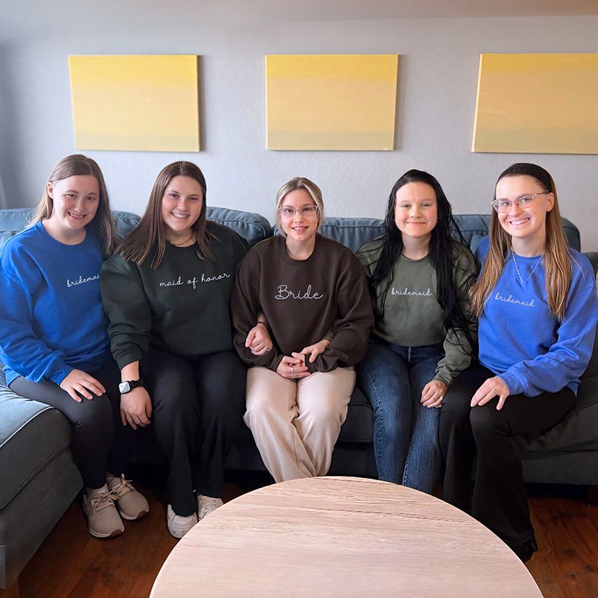 Bride and bridesmaids wearing matching sweatshirts, preparing for the big day.