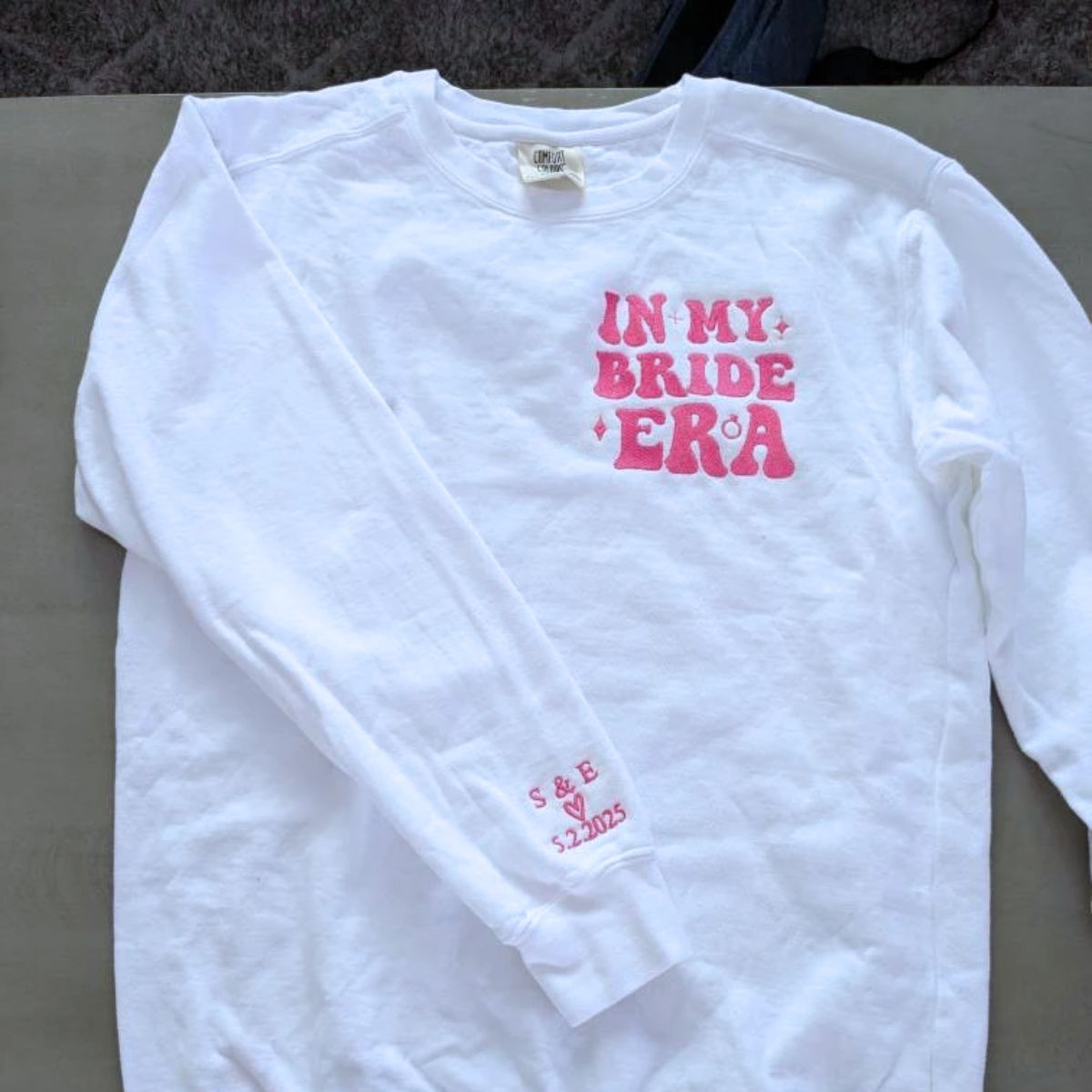 White sweatshirt with 'In My Bride Era' pink embroidery, a cute engagement gift.