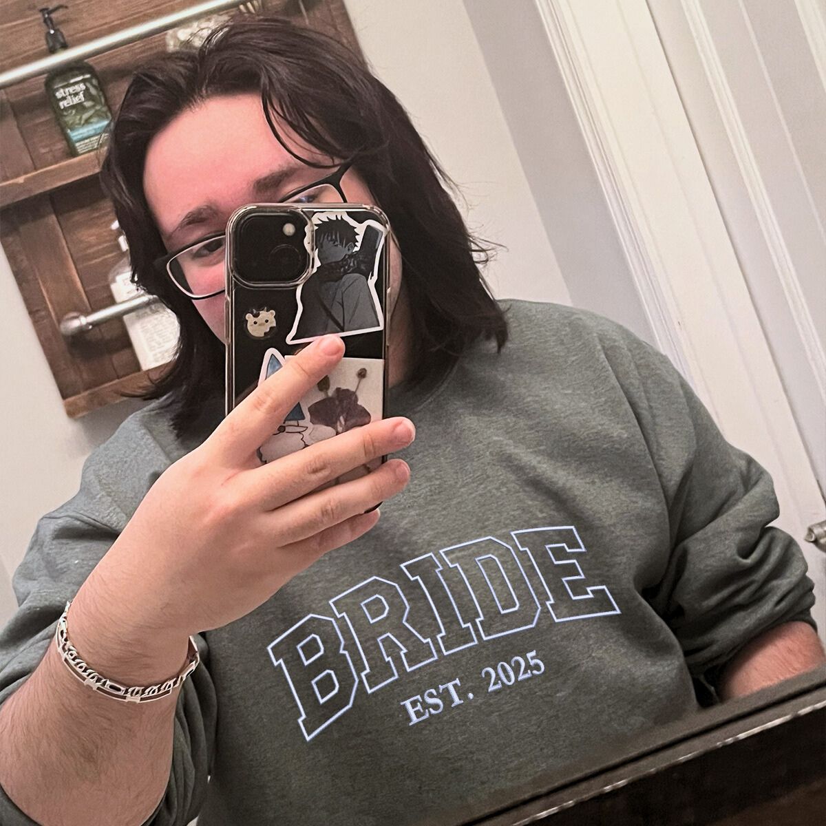 Bride taking a mirror selfie in an embroidered 'Bride Est. 2025' sweatshirt.