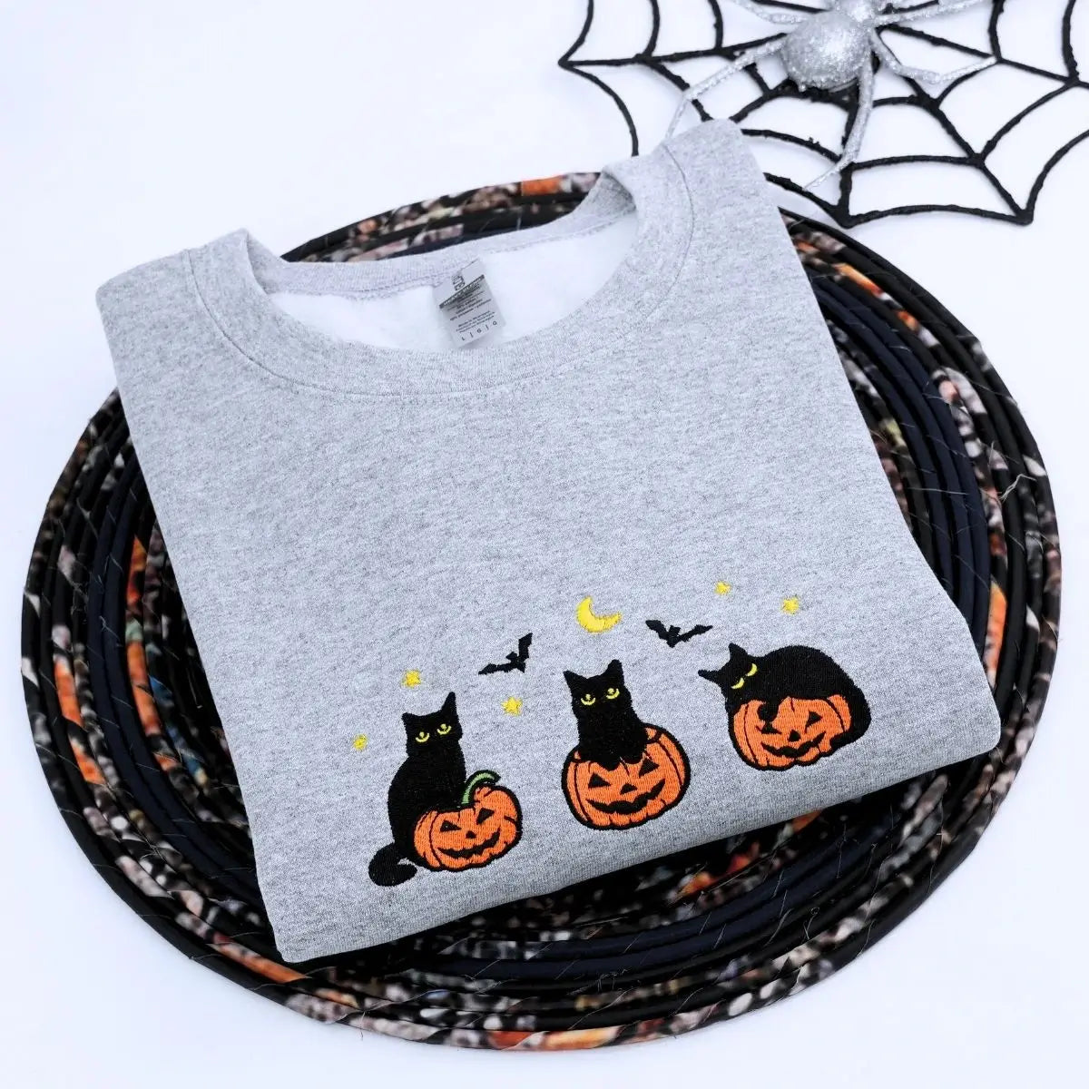 Custom embroidered black cat Halloween sweatshirt with pumpkin, bats, moon and personalized sleeve text