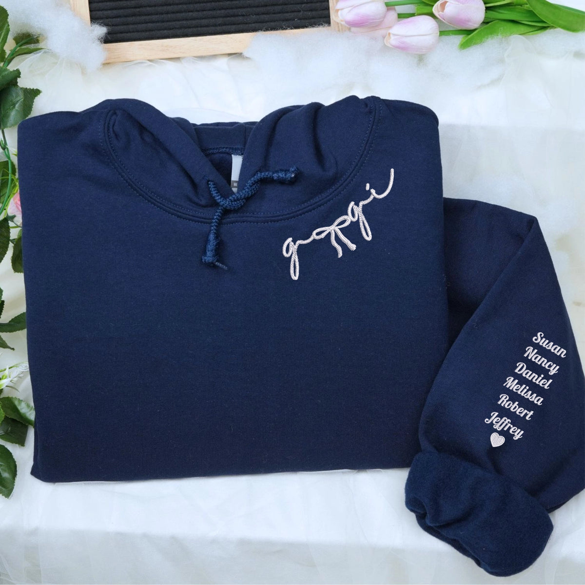 Custom embroidered mama hoodie with coquette bow and kids names stitched on sleeve in soft neutral fabric