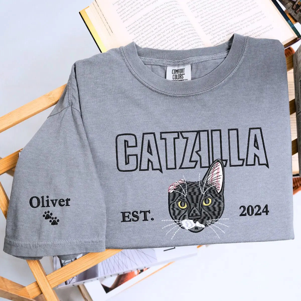 Alt Text suggestion: custom embroidered cat face t shirt with personalized sleeve text