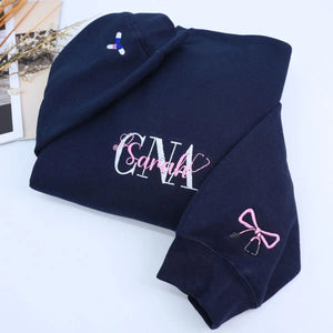 Custom embroidered CNA sweatshirt folded with title visible – perfect nursing graduation gift