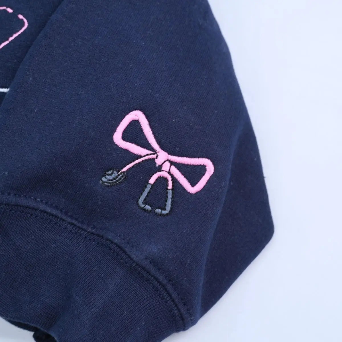 Custom embroidered CNA sweatshirt folded with title visible – perfect nursing graduation gift