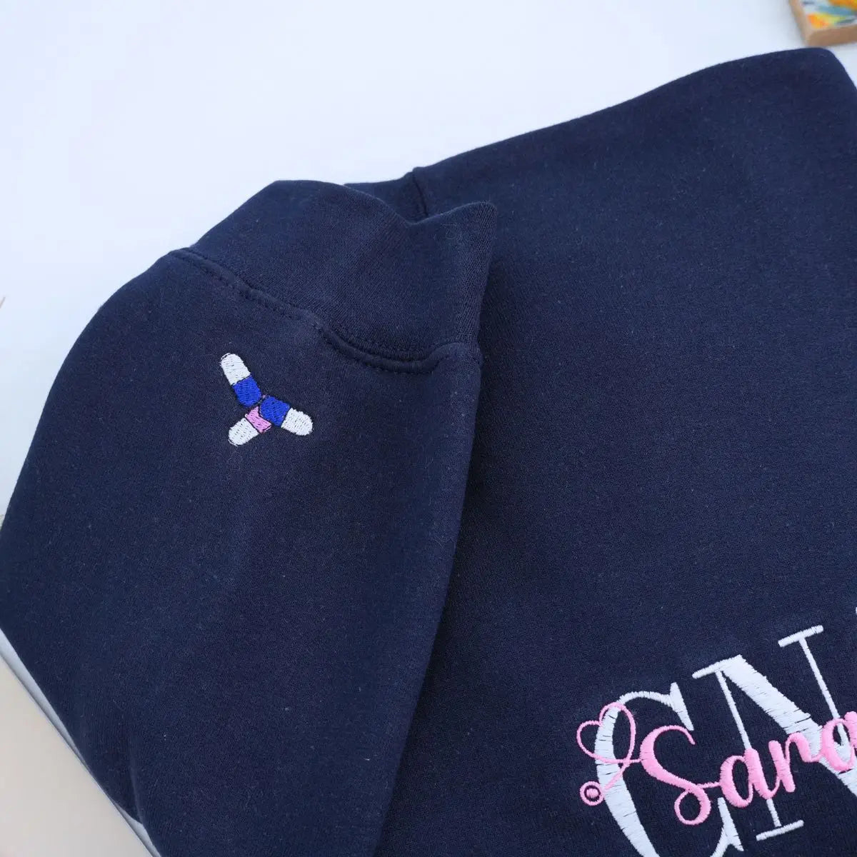 Custom embroidered CNA sweatshirt folded with title visible – perfect nursing graduation gift
