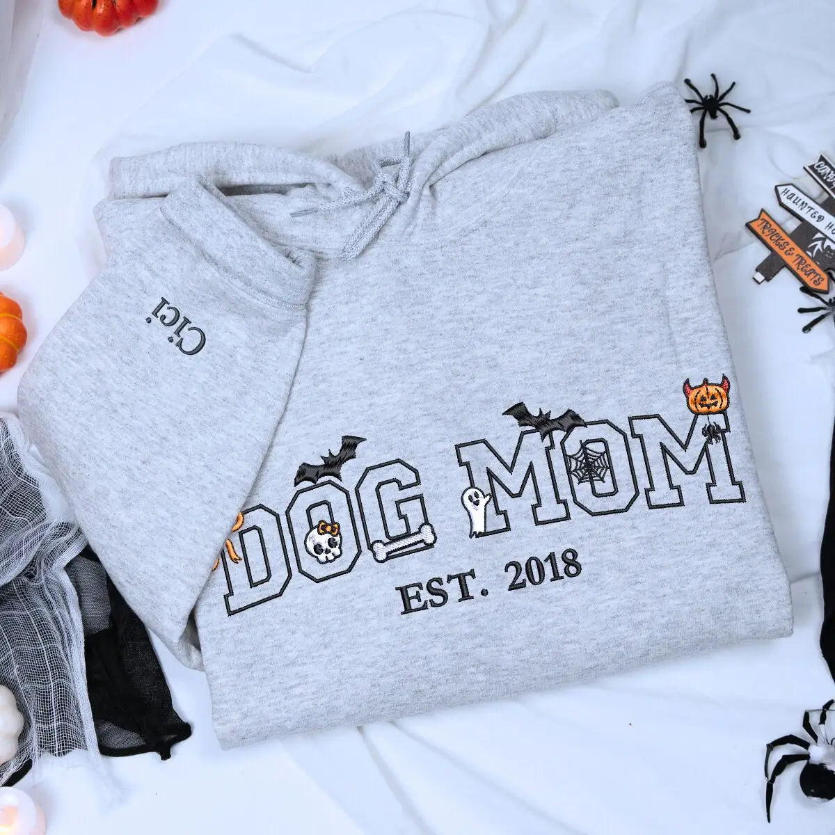 Custom embroidered Halloween hoodie for dog moms with cute pumpkin, ghost, and bones design around “Dog Mom” text