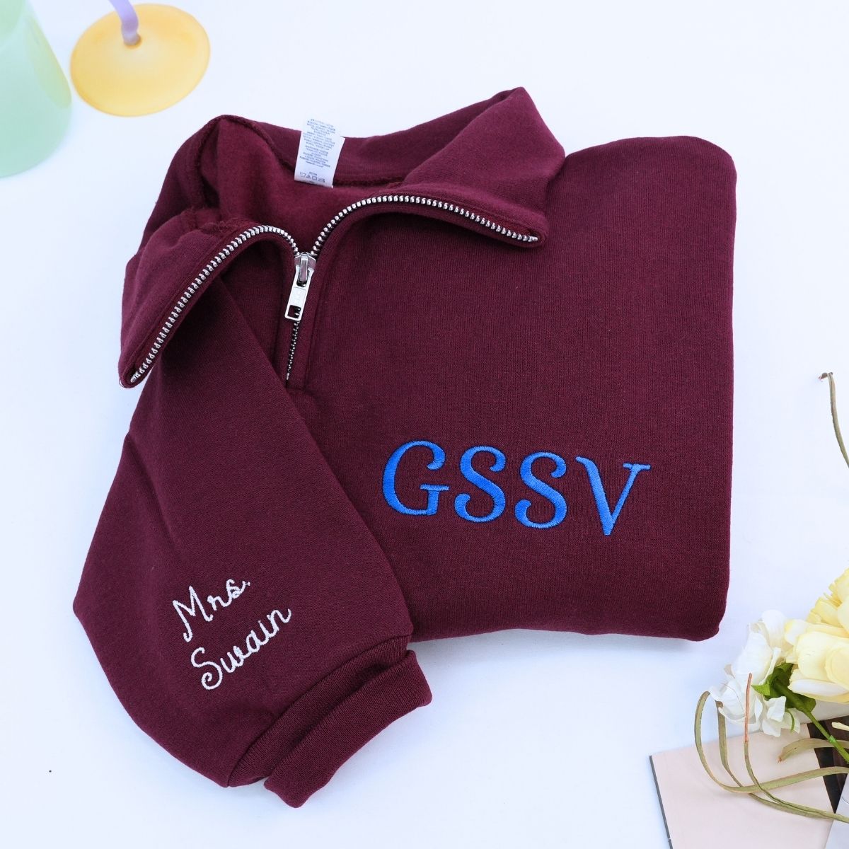 Custom embroidered quarter zip sweatshirt with company logo and text on sleeve, ideal for corporate team apparel.