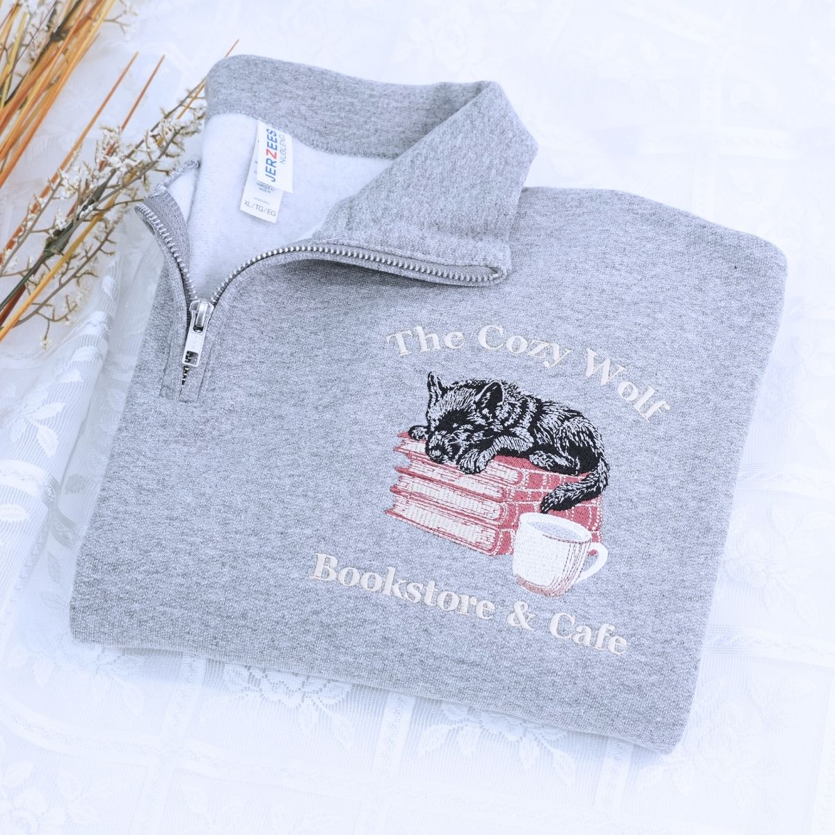 Custom embroidered quarter zip sweatshirt with company logo and text on sleeve, ideal for corporate team apparel.