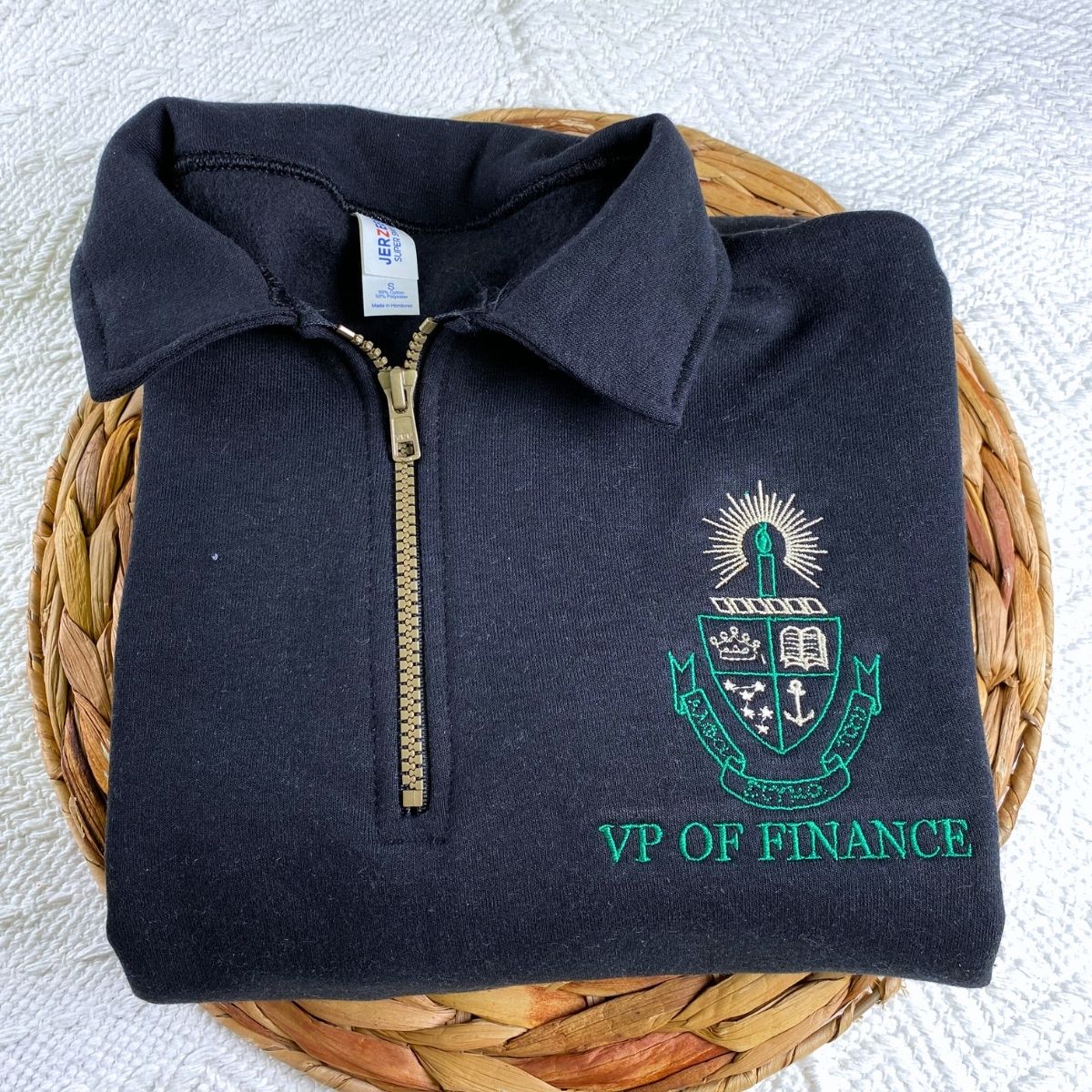 Custom embroidered quarter zip sweatshirt with company logo and text on sleeve, ideal for corporate team apparel.