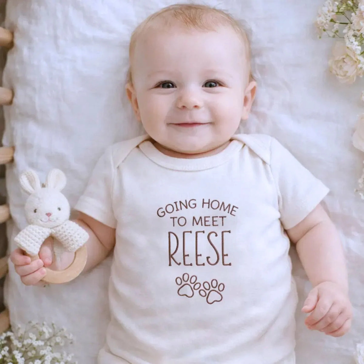 Custom embroidered newborn onesie saying “Going Home to Meet My Pups” – perfect baby shower gift for puppy lovers