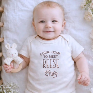 Custom embroidered newborn onesie saying “Going Home to Meet My Pups” – perfect baby shower gift for puppy lovers