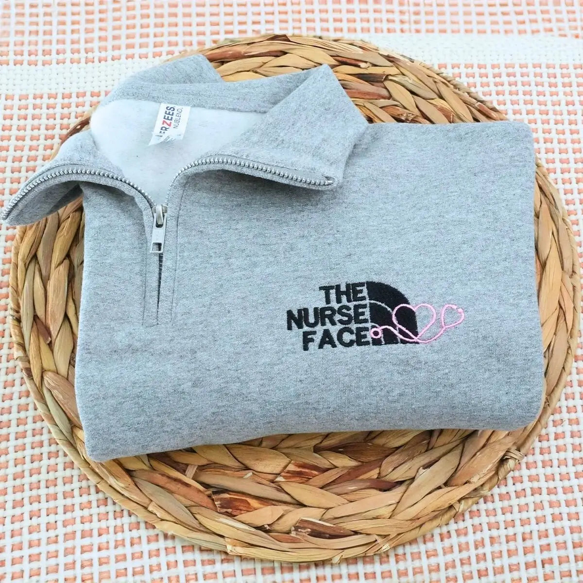 Custom embroidered quarter zip sweatshirt with nurse face design and personalized sleeve text"