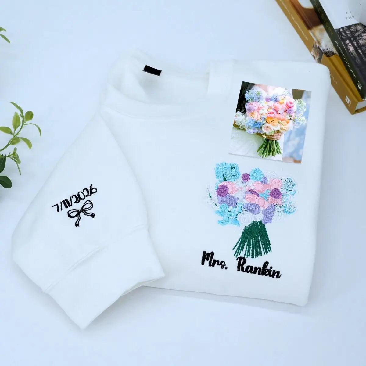 Custom embroidered sweatshirt with wedding bouquet design, personalized with name and date on sleeve