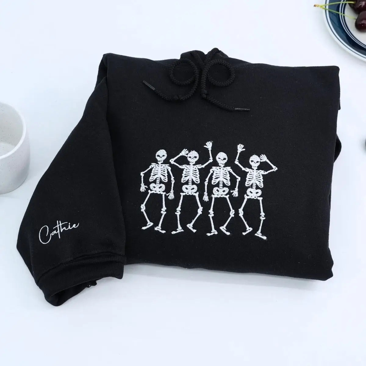 Embroidered hoodie with dancing skeletons design on black cotton fabric, unisex fit