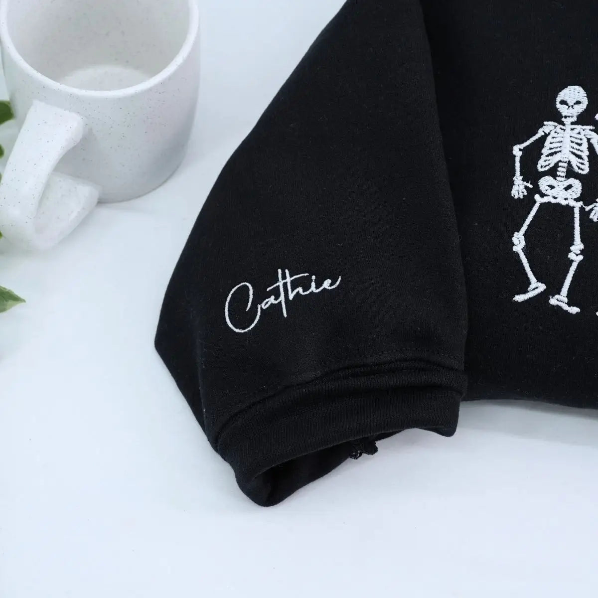 Embroidered hoodie with dancing skeletons design on black cotton fabric, unisex fit