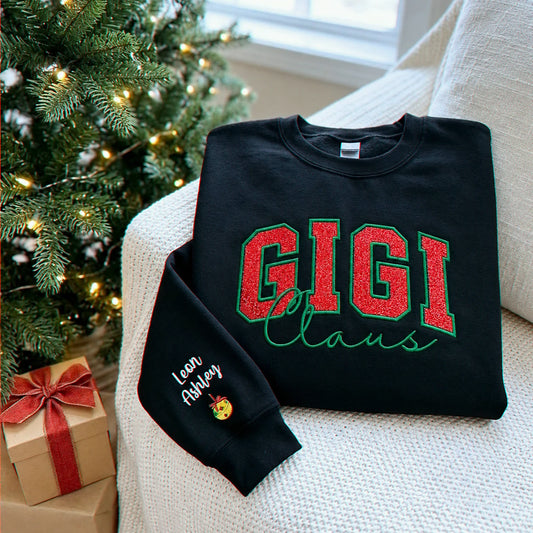 Black Gigi Claus sweatshirt with red glitter embroidery and personalized names on the sleeve.