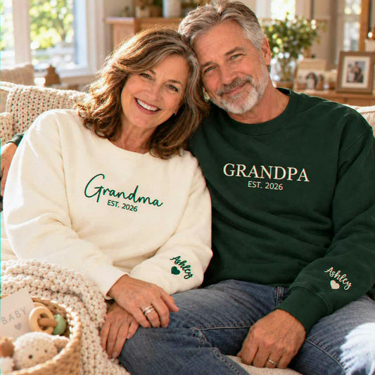 Matching sand Grandma and forest green Grandpa embroidered sweatshirts with personalized grandchild name Ashley on sleeves, perfect for new grandparents gifts, pregnancy announcements, baby reveals, Christmas, and Grandparents Day.