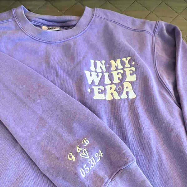 Purple 'In My Wife Era' sweatshirt with custom embroidery on the sleeve.