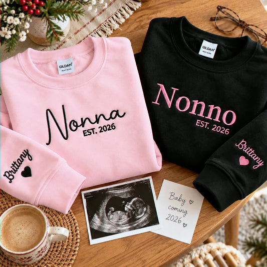 Pink Nonna and black Nonno matching embroidered sweatshirts with personalized grandchild name on sleeves, perfect for pregnancy announcements, first-time grandparents gifts, Christmas, and baby reveal celebrations