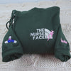 Custom embroidered quarter zip sweatshirt with nurse face design and personalized sleeve text"