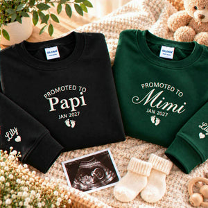 Black Promoted to Papi and forest green Promoted to Mimi embroidered sweatshirts beside an ultrasound photo, a pregnancy announcement gift for future grandparents.